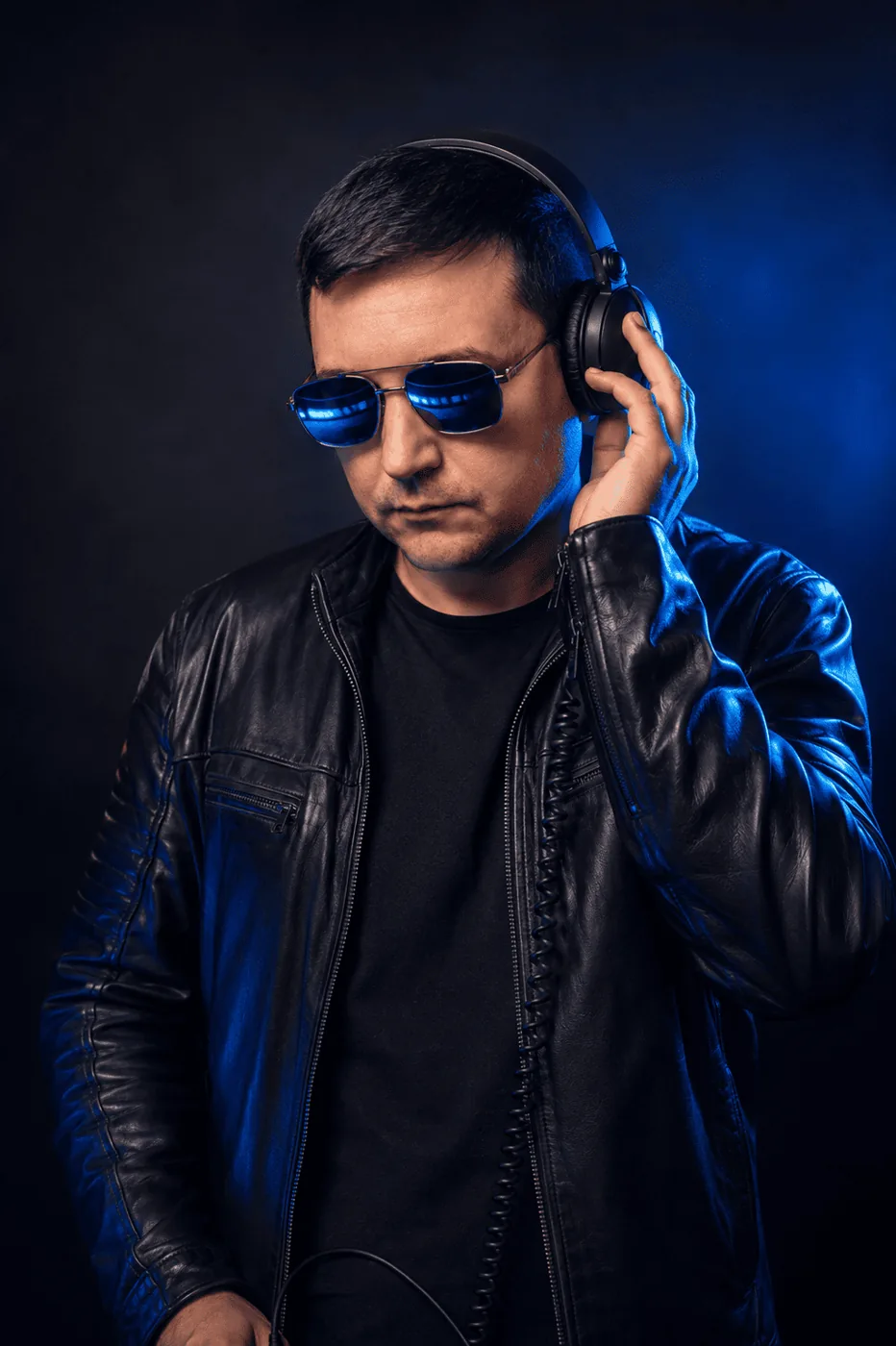 Nyno Ricco com fones de ouvido sob iluminação azul de palco
